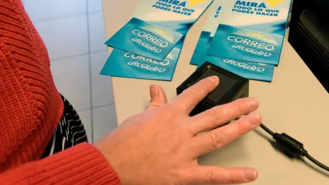 Mujer poniendo huella dactilar en Uruguay para registrarse.