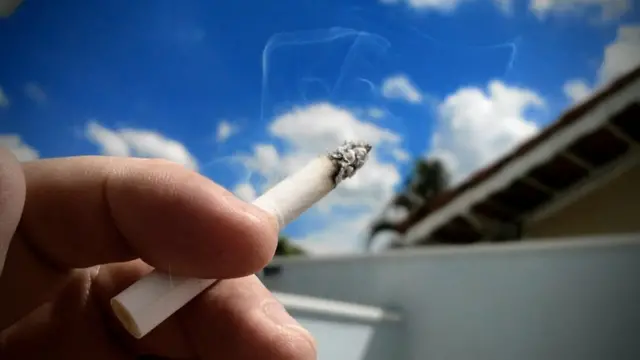 Mão segura um cigarro