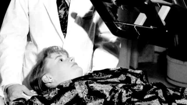 Un médico que trata a una paciente con cáncer de seno