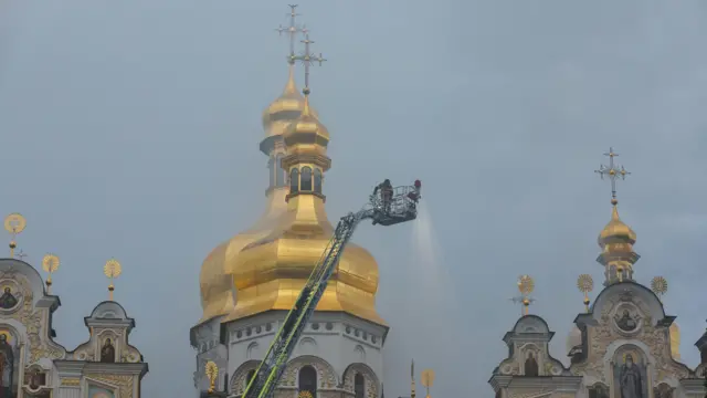 Vatrogasci na platformi gase požar na crkvi, u pozadini zlatne kupole