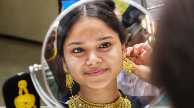 गहने पहनती युवती
