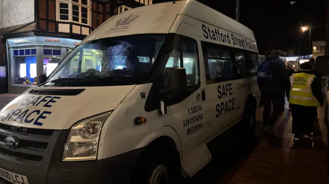Una camioneta blanca grande con la inscripción "espacio seguro" en el capó. En el lateral se lee "Pastores de la calle Stafford, espacio seguro".