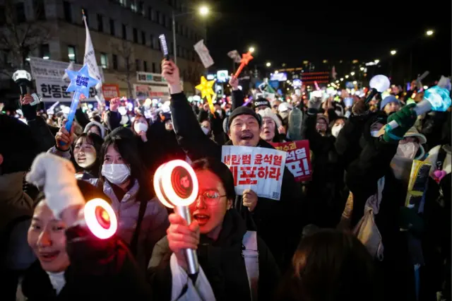 국회 앞에 모인 탄핵 찬성 시위대들이 응원봉을 흔들며 환호하고 있다