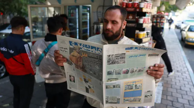 مردی در حال خواندن روزنامه همشهری در تهران