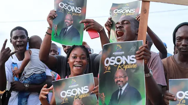 People smiling and holding campaign posters