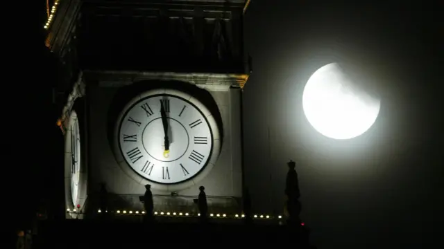 Zaćmienie Księżyca widziane z Warszawy, z zegarem na szczycie Pałacu Kultury