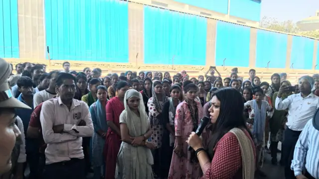नोएडा की ज़िला अधिकारी मेधा रूपम फैक्ट्री मज़दूरों से संवाद करते हुए