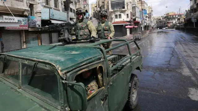 Un vehículo militar jordano patrulla las calles de un Amán vacío. 