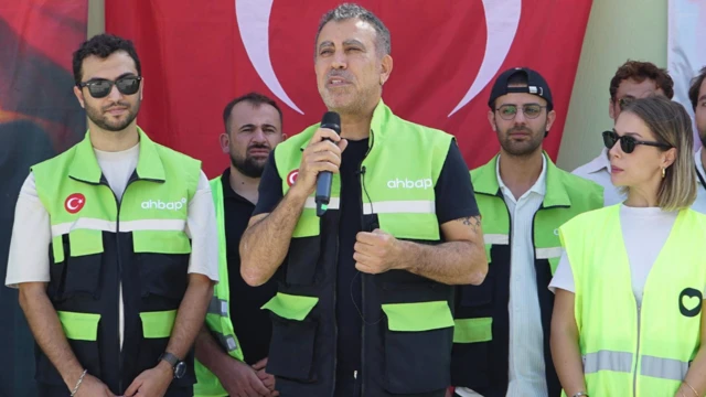 Haluk Levent Ahbap yazılı fosforlu sarı yelek giymiş ve yanında dernek görevlileri var. Onlar da aynı kıyafeti giymişler ve Levent'in yanında ve arkasında konuşmasını dinliyorlar.