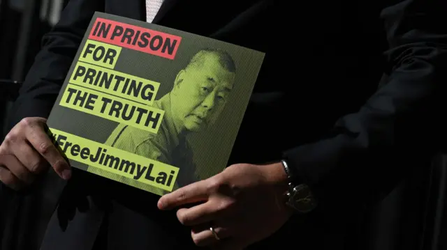 倫敦一場記者會上黎崇恩（鏡頭外）手持一張印上黎智英照片，呼籲讓其獲釋的標語牌（15/9/2025）