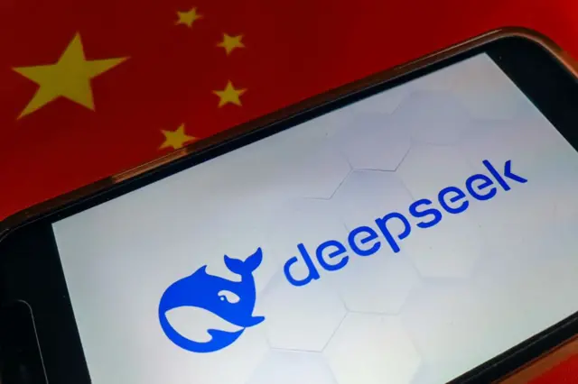 Un teléfono muestra el logo de la compañía Deepseek, el cual es una orca azul al lado del nombre. 