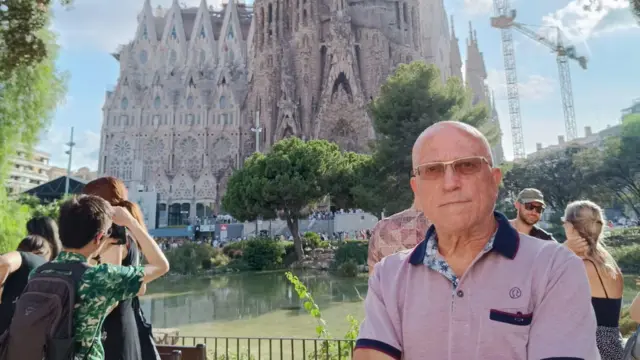 David Soler com a Sagrada Família ao fundo; ele posa para a fotojogo de ganhar dinheiro realpé, com braços cruzados e olhar sério