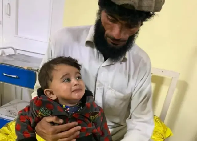 Un adulte tenant un enfant dans ses bras