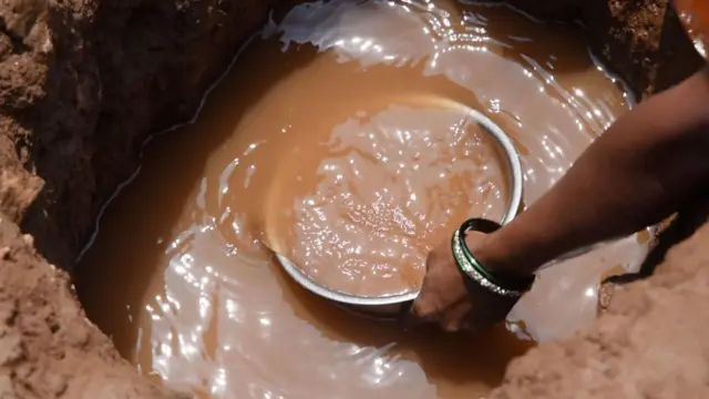 धरणाच्या आटत चाललेल्या पात्रात खड्डे खोदून इथल्या महिला पाणी भरतात 