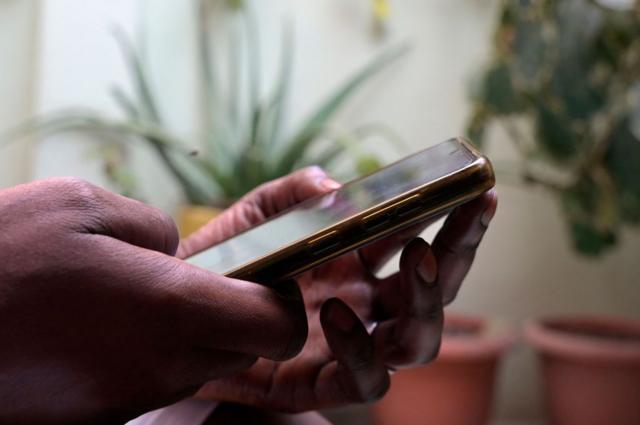Une personne tient un téléphone portable à Dakar le 9 août 2023