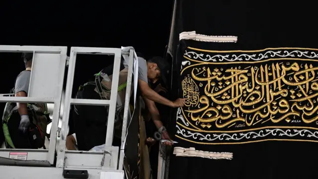 Suudi Arabistan'ın Mekke kentindeki Büyük Camii'de, 7 Temmuz 2024'te işçiler yeni Kisve'nin (Kâbe'yi örten ipek kumaş) parçalarını elle dikiyor.