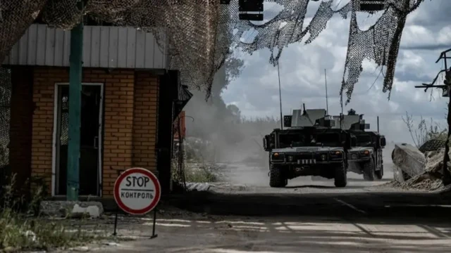 Des militaires ukrainiens quittent à bord de véhicules militaires un point de passage de la frontière avec la Russie dans la région de Sumy, en Ukraine
