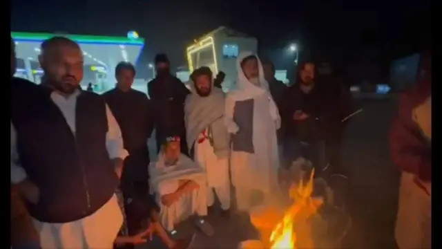 تجمع معترضان طرفدار عمران خان - چند نفر در هوای تاریک در حالی دیده می‌شوند که دور آتش نشسته‌اند که خود را گرم کنند