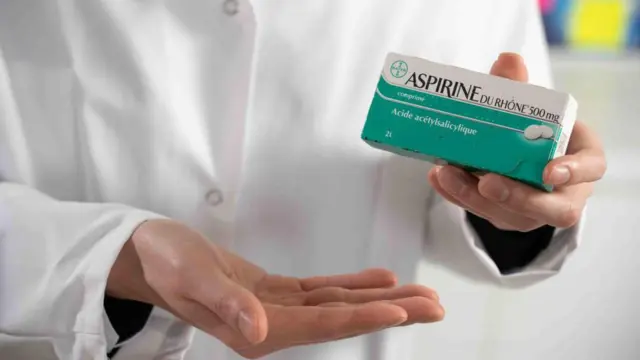 طبيب يمسك علبة أقراص أسبرين