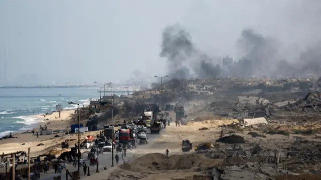 Palestinos desplazados huyen del norte de Gaza a lo largo de una vía junto al mar
