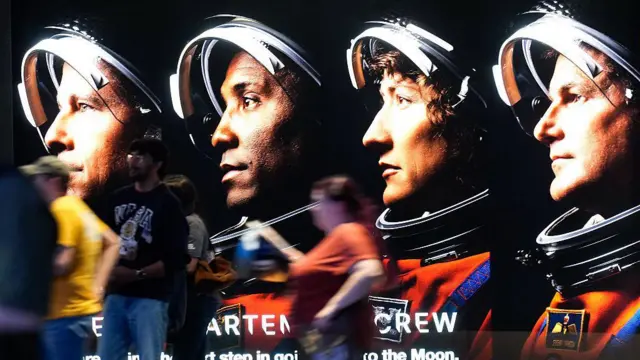 Любители космоса и сотрудники Космического центра имени Джонсона проходят мимо экспозиции, посвященной миссии НАСА «Артемида-2», во время вечеринки по случаю запуска в Хьюстоне в среду, 1 апреля 2026 года.