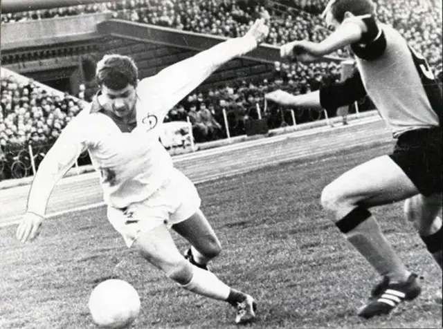 Володимир Мунтян та інший гравець поруч із м'ячем на стадіоні
