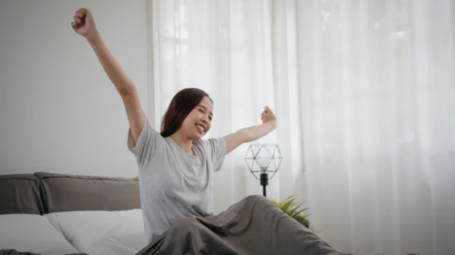 امرأة تتمدد في السرير في غرفتها الخاصة