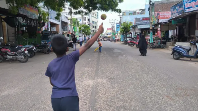 రోడ్డుపై క్రికెట్ ఆడుతున్న పిల్లల ఫోటో
