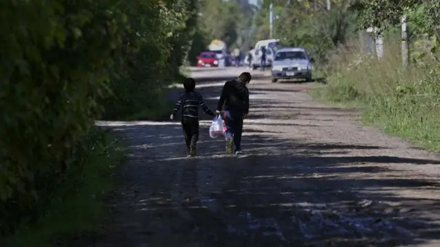 Children walk carrying a bag with food served at "El Lucero" soup kitchen in Belen de Escobar, Buenos Aires province, Argentina