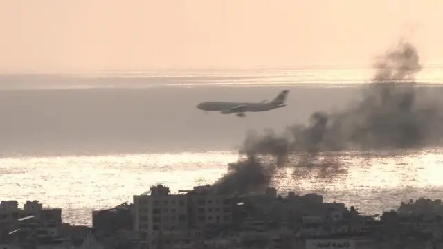 Avião sobrevoando Beirute; na cidade, é possível ver fumaça