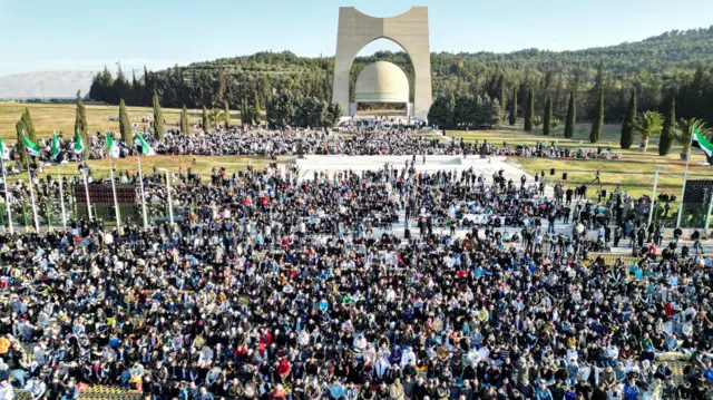 منظر عام لأشخاص يؤدون الصلاة في ساحة الجندي المجهول خلال أول عيد فطر بعد سقوط حكم الأسد في دمشق