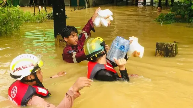 လူမှုကူညီရေးအဖွဲ့ဝင်တွေက ဒေသခံတွေအတွက် ထမင်းထုပ်နဲ့ ရေသန့်ဘူးတွေ မျှဝေပေးနေတဲ့မြင်ကွင်း