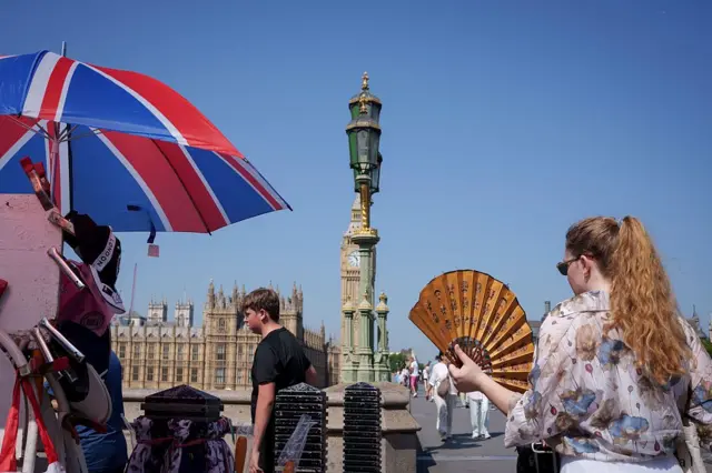 Жара в Великобритании: безоблачное небо над зданием парламента, люди под зонтами и с веерами