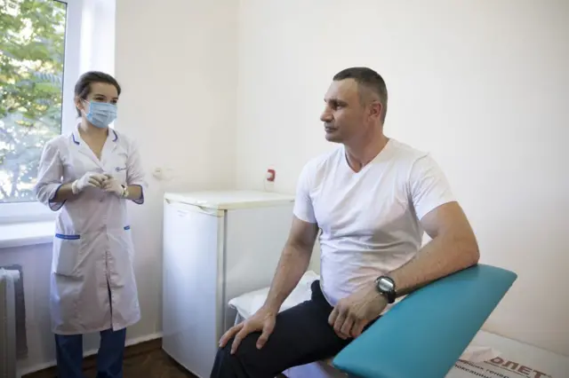 Віталій Кличко у лікарні на вакцинації сидить на кушетці, поруч - медсестра