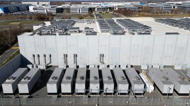 З висоти пташиного польоту видно вентилятори охолодження на даху поруч із генераторами на нижньому рівні центру обробки даних Digital Realty в Ашберні, штат Вірджинія