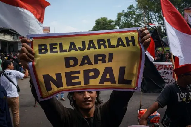 Seorang pria memegang spanduk bertuliskan "Belajar dari Nepal" saat para demonstran memprotes untuk menuntut pengunduran diri Bupati Sudewo atas tuduhan korupsi, di Pati, Jawa Tengah, pada 19 September 2025. 