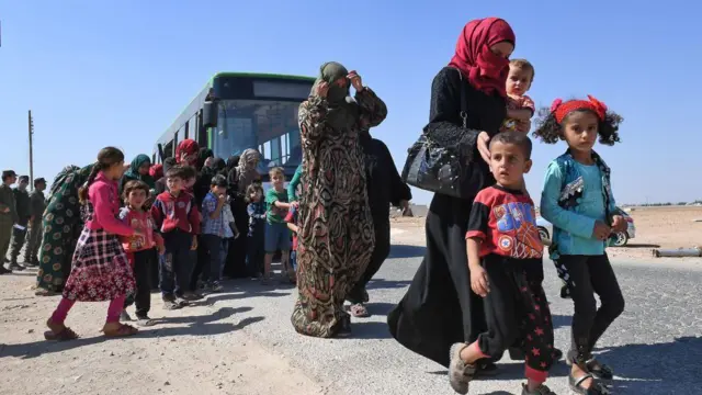 Syrians arrive at the Abu Duhur crossing on the eastern edge of Idlib province on September 25, 2018, as they cross from rebel-held areas to regime-held areas