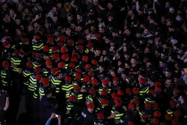 حاجز أمني يقيّد حركة المتظاهرين خلال مسيرهم قرب السفارة الإسرائيلية في عمان 