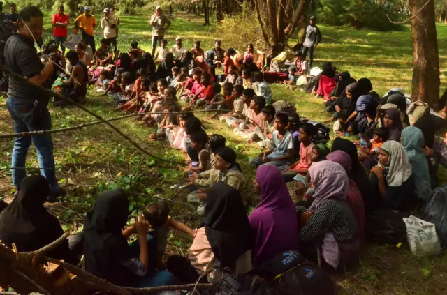 Rohingya refugees gather as they are inspected by local authority officers in East Aceh