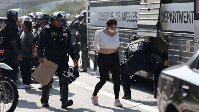 Арестованную ведут к автобусу