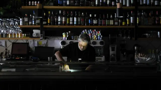 Homem trabalha em um restaurante no escuro em Madri. 