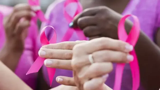 Des femmes exhibant le logo d'octobre rose.