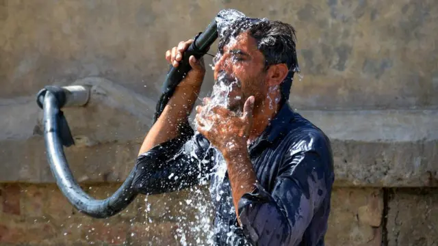 গরমে শরীর শীতল করার চেষ্টা করছেন এক ব্যক্তি