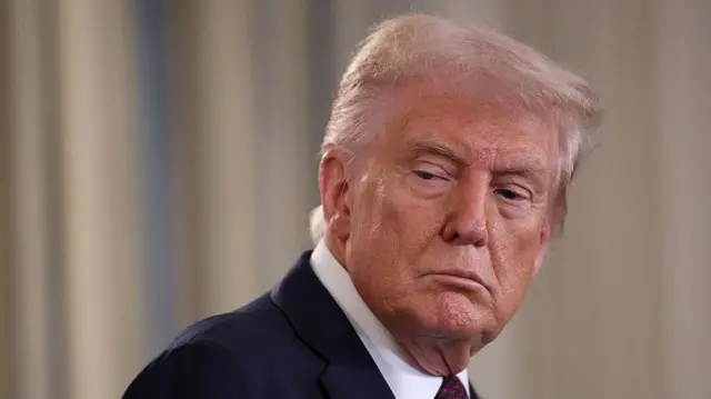 El presidente de Estados Unidos, Donald Trump, mira de lado con gesto serio