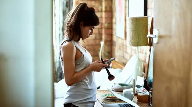 ফোন হাতে স্ক্রলিংয়ে ব্যস্ত এক তরুণী