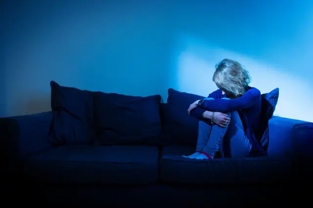 صورة تعبيرية تظهر امرأة تجلس بوضعية تدلل على الحزن والاكتئاب.