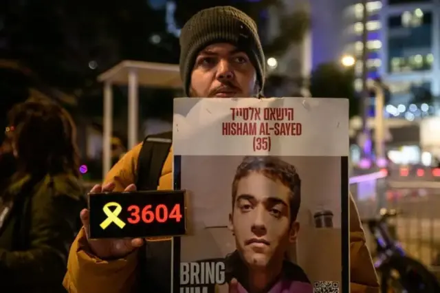 یو تن چې د فلسطیني اصله اسرائیلي بندي هشام سید انځور یې جګ نیولی او د هغو ورځو شمېر یې ورسره لیکلی چې په بند کې یې تېرې کړې (۳۶۰۴ ورځې).
