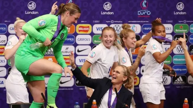 Wiegman es vista celebrando con sus jugadoras en un evento de prensa
