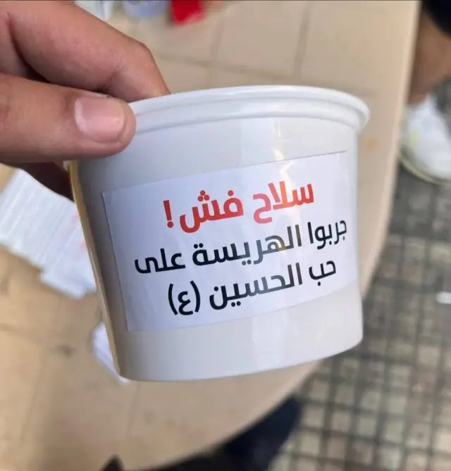المضائف العاشورائية في الضاحية الجنوبية توزع الهريسة بعلب كتب عليها "سلاح فش.. جربوا الهريسة على حب الحسين"