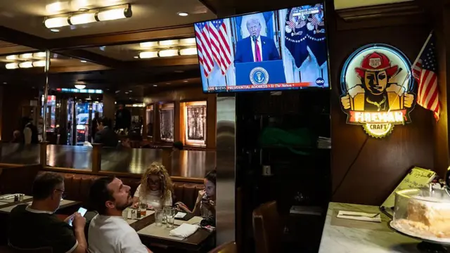 न्यूयॉर्क में टेलीविज़न पर डोनाल्ड ट्रंप का भाषण देखते लोग